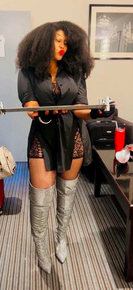Full length in a black shirt dress and sparkling silver thigh-high boots.